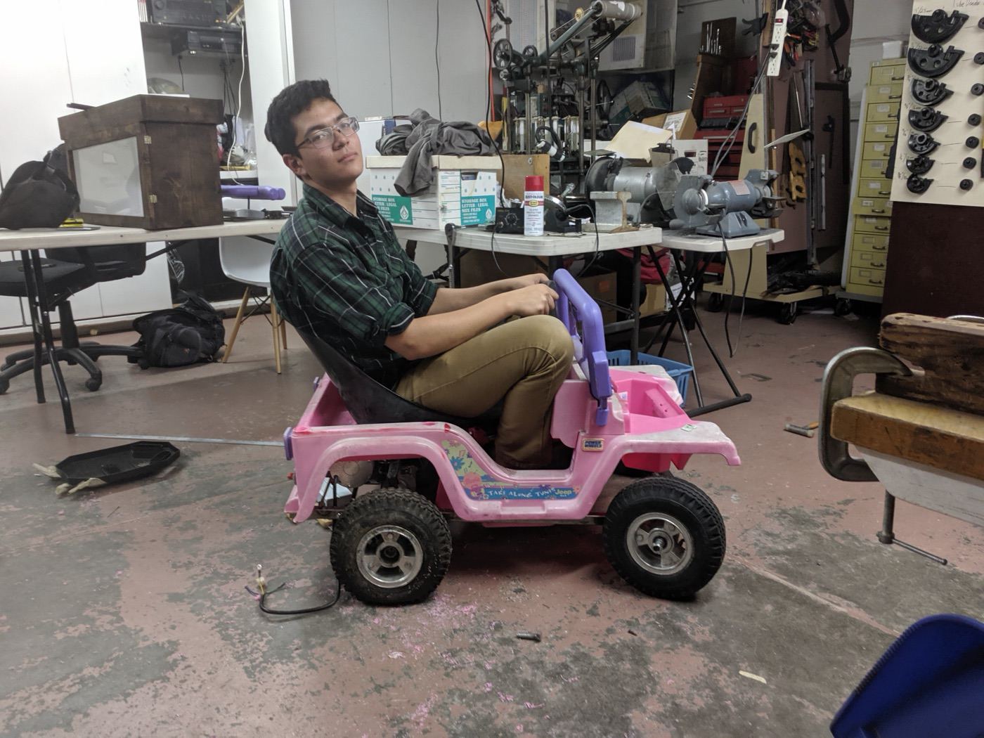 Spencer test-fitting the modified Barbie Jeep in the shop